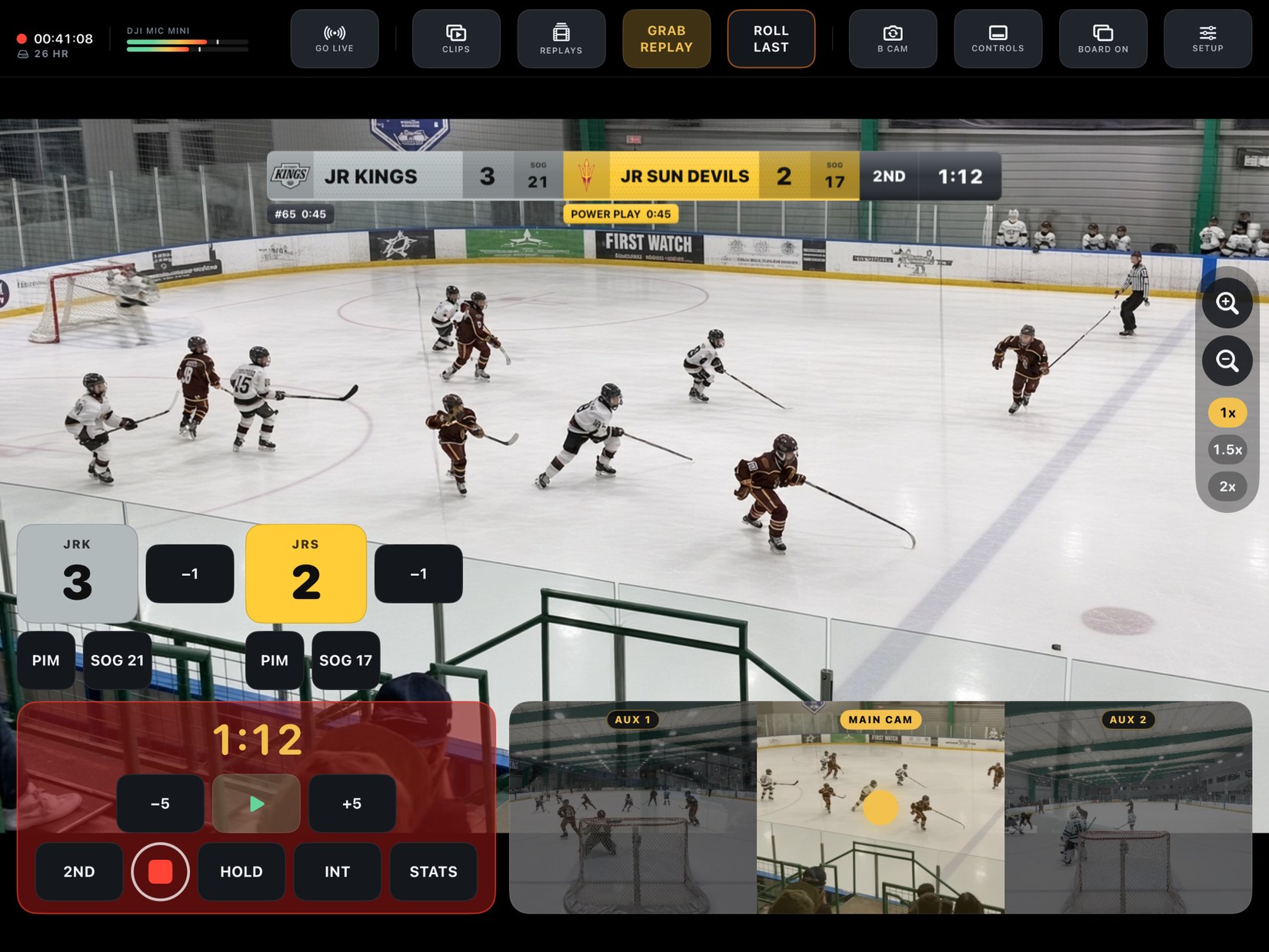 Dad Sports Network running on iPad: a youth hockey game live, the scoreboard burned into the picture with a power play on the clock, and the Touch Track pad showing AUX 1, MAIN CAM and AUX 2 live.