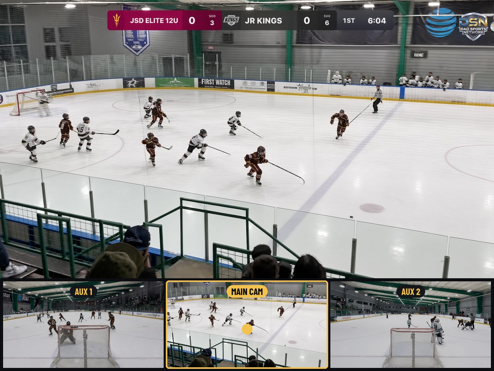 Touch Track: the main camera on air at center ice with the scoreboard burned in; below it the touch pad's three live pictures — AUX 1 on one end, MAIN CAM lit gold at center ice, AUX 2 on the other end.